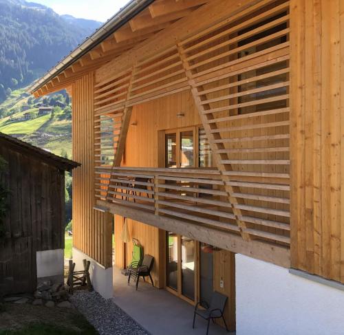 Casa de madera con balcón con 2 sillas en Villa Smilla, en Gaschurn