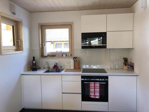 a kitchen with white cabinets and a stove top oven at Villa Smilla in Gaschurn