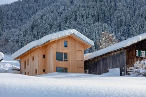 a building covered in snow with snow on the roof at Villa Smilla in Gaschurn