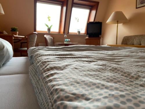 a large bed in a room with two windows at Gasthaus Neue Mühle in Westhausen
