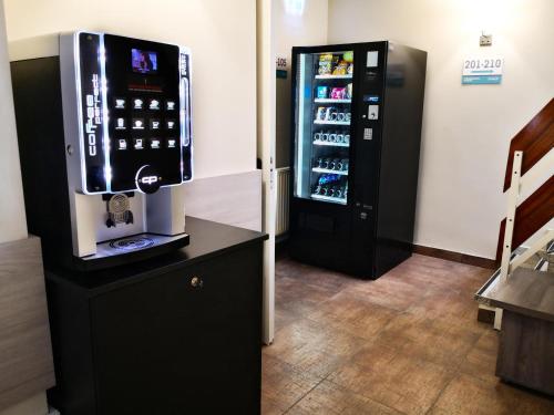 uma máquina de bebidas está ao lado de um frigorífico preto em Terminal Park em Bischofsheim