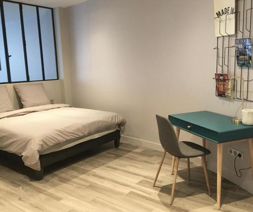 a bedroom with a bed and a desk and a chair at 2 pieces proche metro, Montrouge in Montrouge