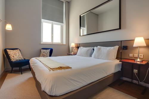 a bedroom with a large bed and a mirror at 8 Building Serviced Apartment by the River in Lisbon