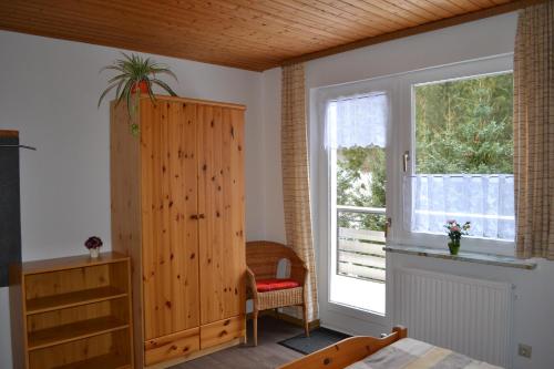 1 dormitorio con armario de madera y ventana en Ferienwohnungen Edelweiss, en Schulenberg im Oberharz