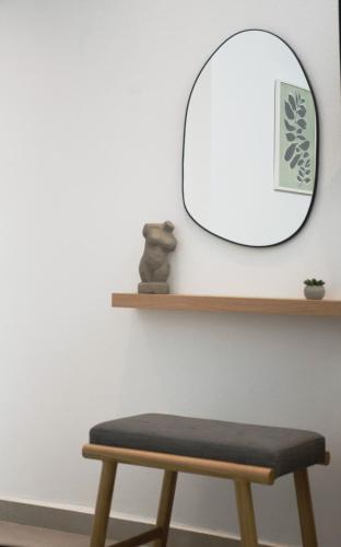 a stool sitting on a shelf with a mirror at IADES suites in Afitos