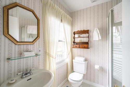 a bathroom with a toilet and a sink and a mirror at Abacot Hall Bed & Breakfast in Niagara on the Lake
