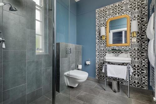 a bathroom with a toilet and a sink and a mirror at St Martins Lodge in Leicester
