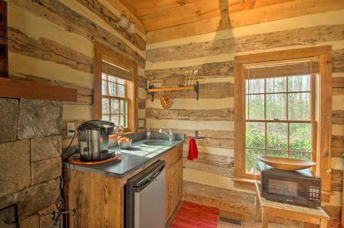 una cucina con pareti in legno, piano cottura e lavandino di Lovely Wooded Cabin with Numerous Trails On-Site! a Earlysville