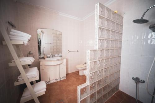 a bathroom with a sink and a toilet and a mirror at Alojamiento rural antigua fragua in El Real de la Jara