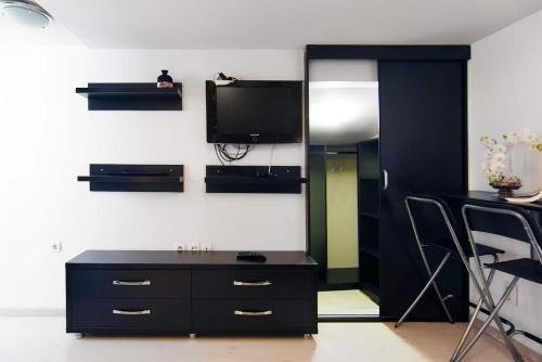 a living room with a black dresser and a tv at Carol Studio in Bucharest