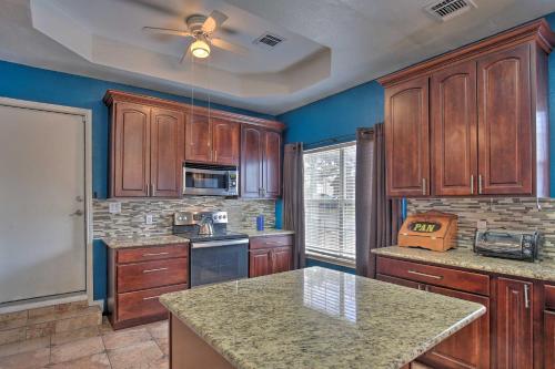 a kitchen with wooden cabinets and a counter top at San Antonio Home with Pool and Hot Tub Near SeaWorld! in San Antonio