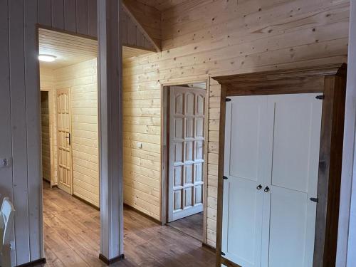 an empty room with wooden walls and two doors at Restauracja i Noclegi Izba Rybacka w Krainie Wygasłych Wulkanów in Podgórki