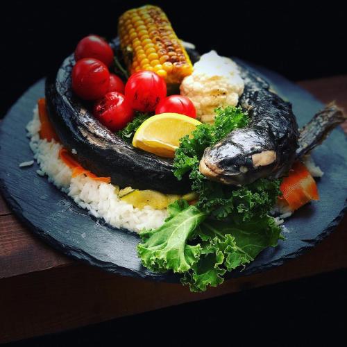 a plate of food with rice and vegetables on it at Restauracja i Noclegi Izba Rybacka w Krainie Wygasłych Wulkanów in Podgórki