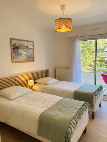 deux lits dans une chambre avec une fenêtre dans l'établissement MILN - Balcon, Parking privé, Plage 100m - T11, à Carnac
