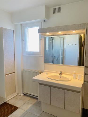 une salle de bain avec un lavabo et un grand miroir dans l'établissement MILN - Balcon, Parking privé, Plage 100m - T11, à Carnac