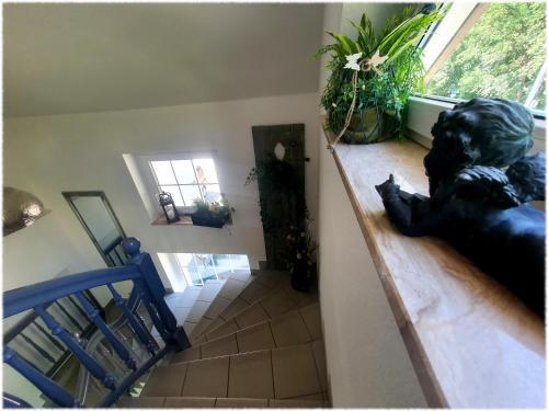 un escalier avec une statue assise sur une rampe dans une maison dans l'établissement Pension Miss Sophie, à Kyritz