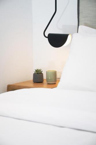 a plant sitting on a nightstand next to a bed at IADES suites in Afitos