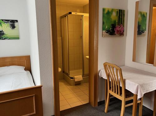 a small room with a table and a shower at Hotel-Pension Sternen in Klaus