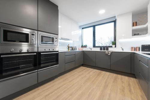 cocina con electrodomésticos de acero inoxidable y suelo de madera en Yugo Explore - Ardcairn House, en Dublín