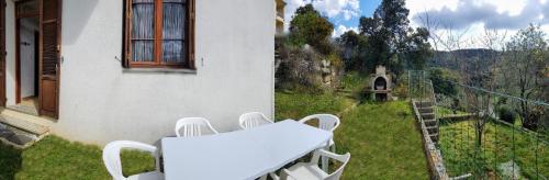 a balcony with a table and chairs on the grass at Grande Maison de vacances in Santa-Maria-Siché