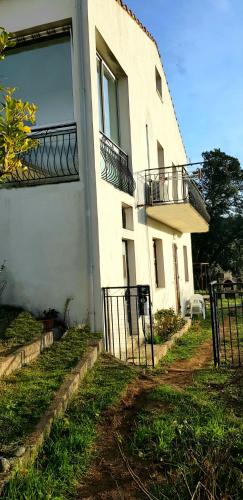 a white building with a balcony on the side of it at Grande Maison de vacances in Santa-Maria-Siché