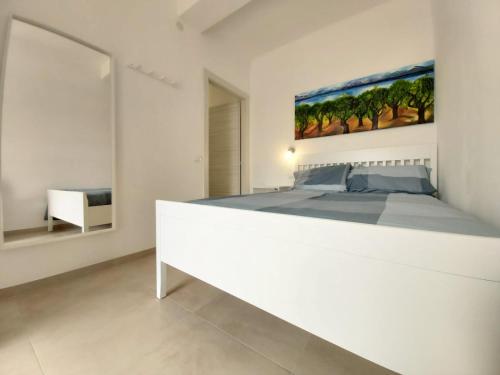 a white bedroom with a bed and a painting on the wall at Bergamo Allegra in Bergamo