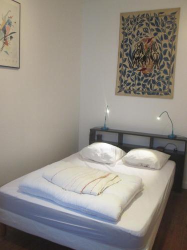 un lit dans une chambre avec un tableau sur le mur dans l'établissement LES PAILLETTES, à Le Touquet-Paris-Plage