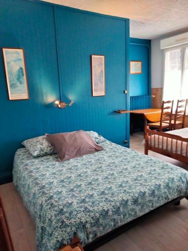 um quarto com uma parede azul e uma cama em Le gibergeon em Signy-lʼAbbaye
