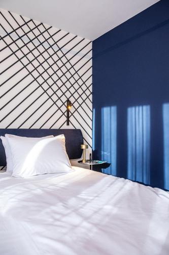a bedroom with a white bed and blue walls at Hotel Čad in Ljubljana