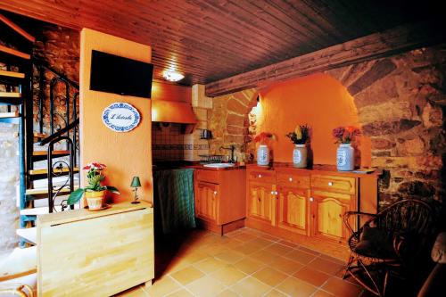 a kitchen with wooden cabinets and a stone wall at Artesola in Onda