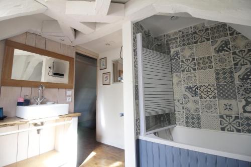 Gîte Lamarmette في Lanquais: حمام مع حوض وحوض استحمام