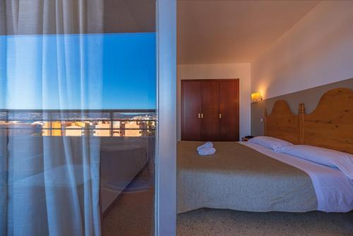 a bedroom with a bed and a view of the ocean at Xon's Platja HA in Empuriabrava