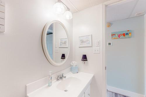 een witte badkamer met een wastafel en een spiegel bij Ocean Towers 3A in Ocean City