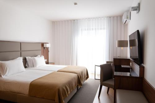 a hotel room with a bed and a window at Hotel Freixo Douro Superior in Freixo de Espada à Cinta