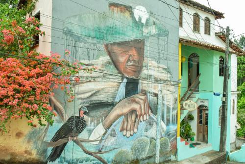 a mural of a woman with a bird on the side of a building at Casa da Mineira Hospedaria in Lençóis