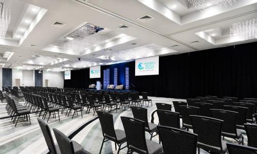 a room filled with chairs and a stage with a screen at Perdido Beach Resort in Orange Beach