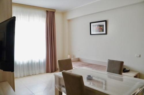 a living room with a dining table and a television at Hotel Roscianum Welness SPA in Rossano