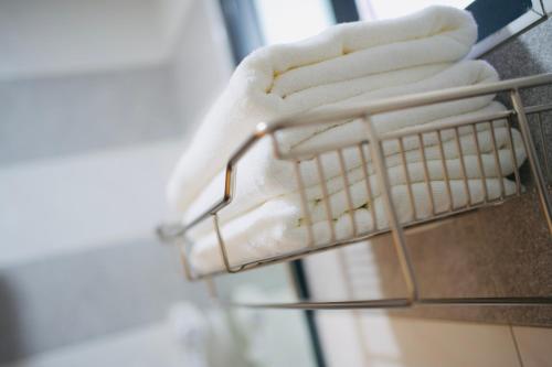 a towel rack with white towels on it at It's Mine Hostel in Taitung City