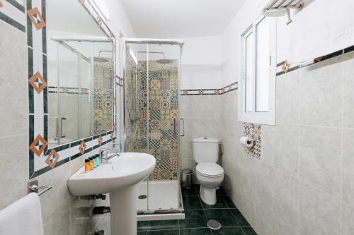 a bathroom with a toilet, sink, and tub at Cinco Bolas in Málaga
