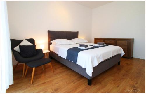 1 dormitorio con 1 cama y 1 silla en Apartman Silicon, en Primošten