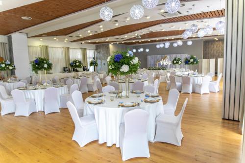 a banquet hall with white tables and white chairs at Hotel nad Wisłą in Tczew