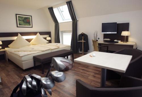 a hotel room with a bed and a table at Hotel im Kornspeicher in Marburg an der Lahn