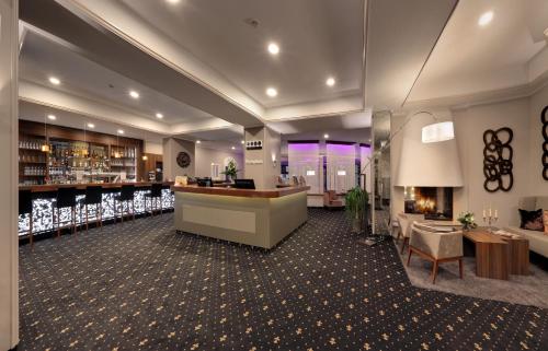 a lobby of a hotel with a counter and a bar at Hotel Am Schloss Aurich - Schlossresidenz in Aurich