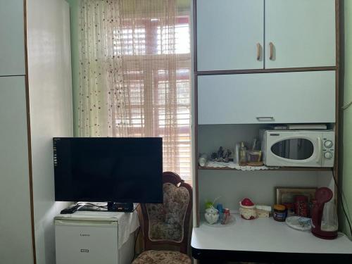 telewizor siedzący na stole w kuchni w obiekcie Rosa Guest House w mieście Hajfa