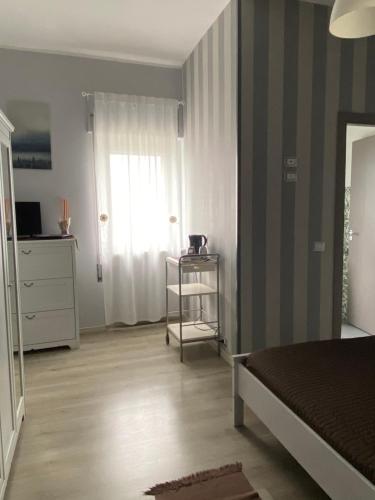 a bedroom with a bed and a dresser and a window at Enna Inn Centro in Enna
