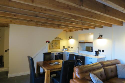een keuken en een woonkamer met een houten plafond bij Farthing Cottage in Bishop Auckland