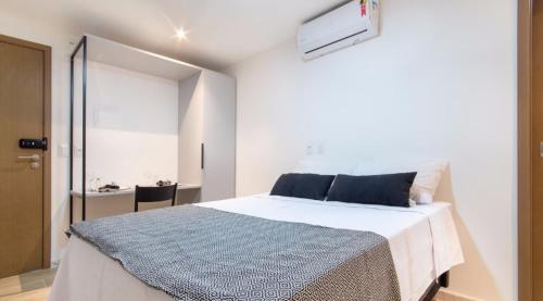 a bedroom with a large bed with a blue blanket at Flat Encantador Bauten Cabo Branco in João Pessoa
