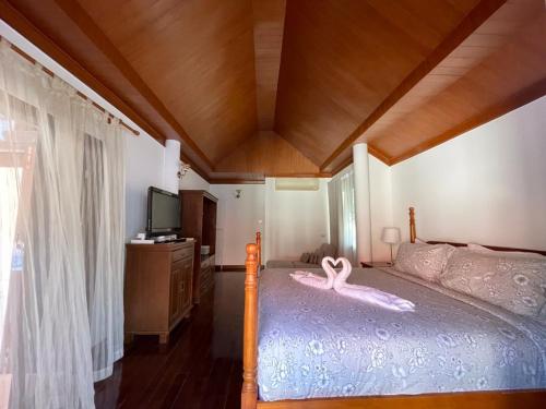 a swan decoration on a bed in a bedroom at Casa Khaoyai Bed&Breakfast in Mu Si