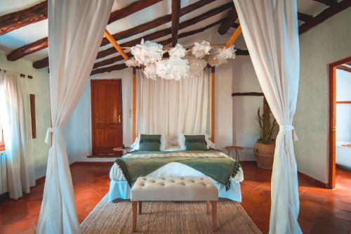 a bedroom with a bed and a chandelier at VILASIRA ( Rooms & Wines ) in Los Cojos
