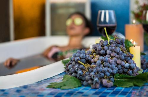 a bunch of grapes on a table with a woman in the background at Hotel La Calma De Rita - Pirque in Pirque